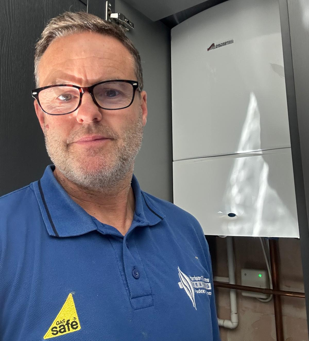 Gas Safe registered engineer beside a boiler during a gas safety check in Liverpool